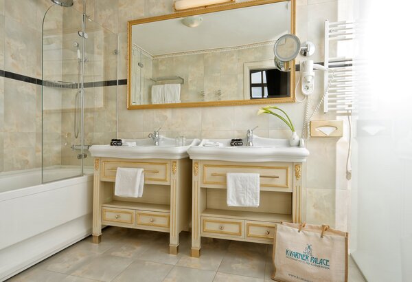 Helles Badezimmer mit zwei Waschbecken, einem großen Spiegel und einer Dusche. Die Wände sind in neutralen Farbtönen gehalten, und es gibt eine Badewanne. Handtücher hängen an den Waschbecken, und ... Kaiserliche Suiten im Hotel mit Meerblick Kroatien