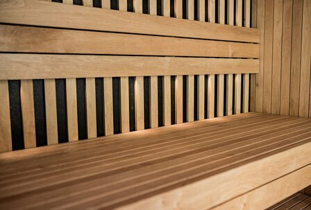 Holzsauna mit einer langen, schlichten Bank und vertikalen Holzlatten an den Wänden, die eine entspannende Atmosphäre schaffen. Holzsauna mit einer langen, schlichten Bank und vertikalen Holzlatten an den Wänden, die eine entspannende Atmosphäre schaffen.