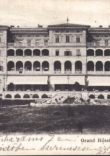 Historisches Grand Hotel "Erzherzog Josef" in Crikvenica, beeindruckende Architektur mit mehreren Balkonen und großen Fenstern, umgeben von gepflegten Grünflächen. Die Fassade strahlt Eleganz und Nostalgie aus.